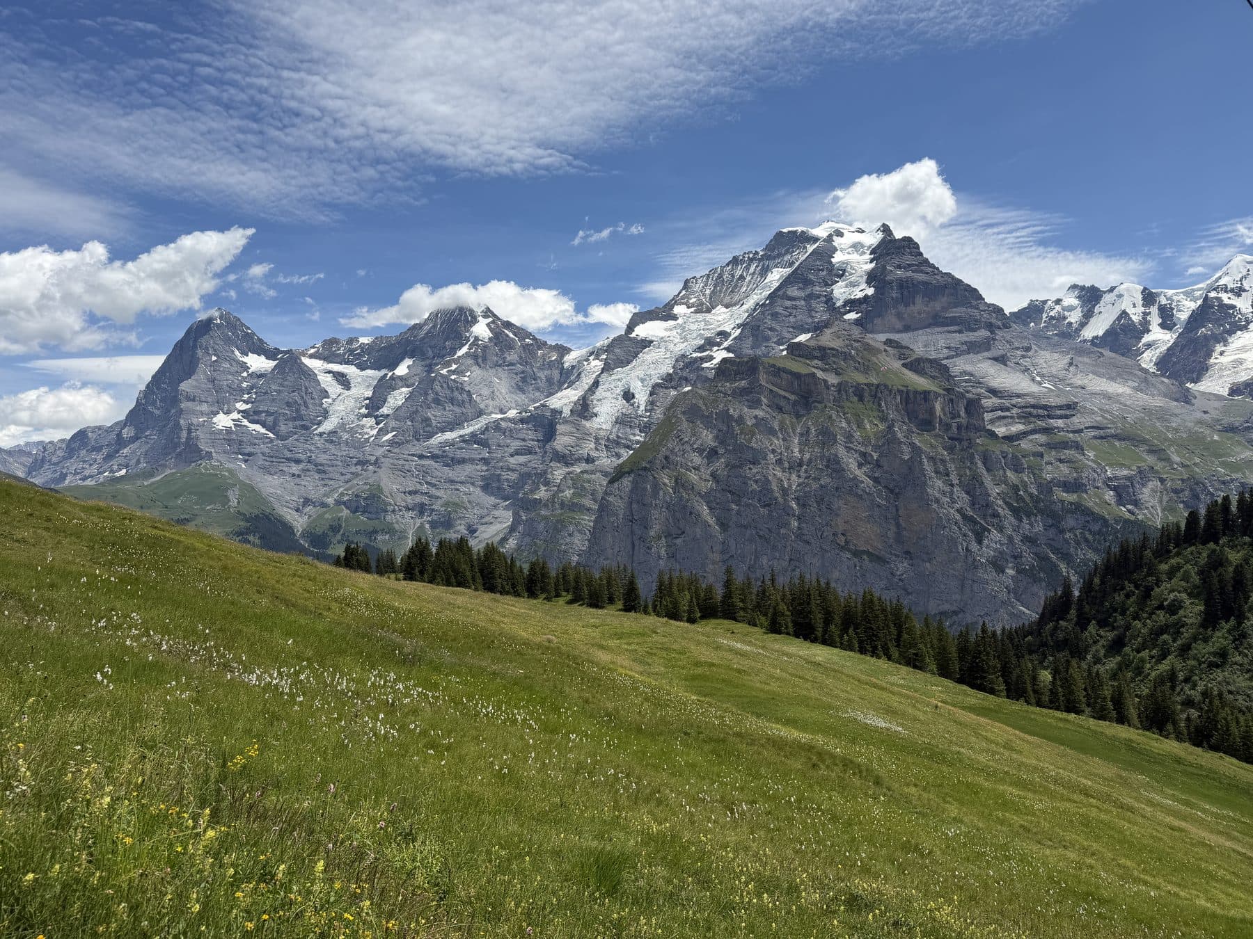 Snow-capped alpine peaks above green meadows near Mürren
