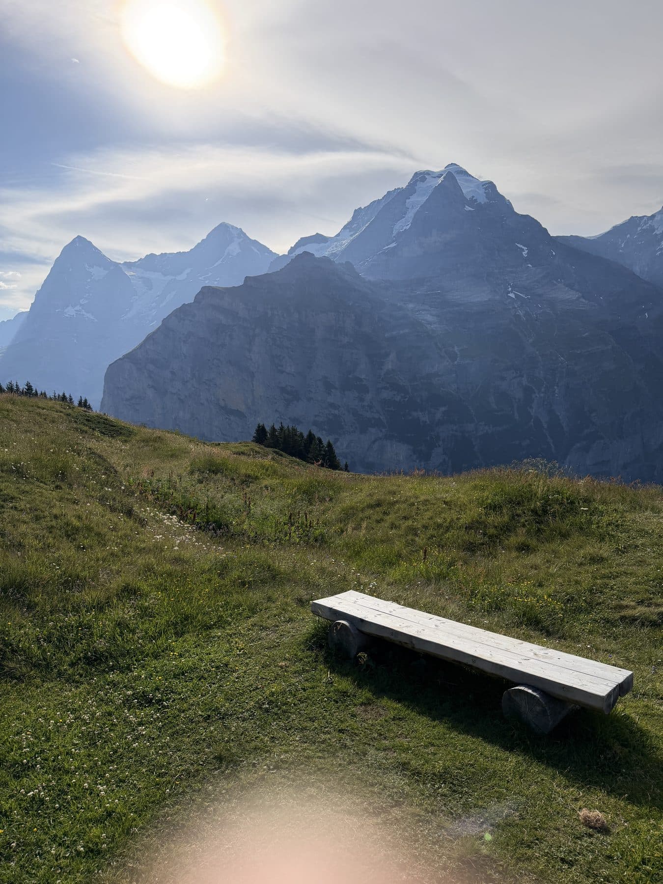 Wooden bench overlooking cliffs and snowy peaks